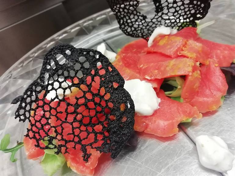 Salmone marinato agli agrumi, panna acida e corallo nero
