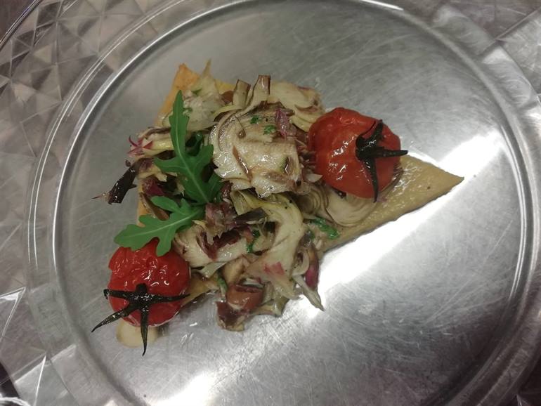 Farinata di ceci, insalatina di carciofi, olive e pomodori confit